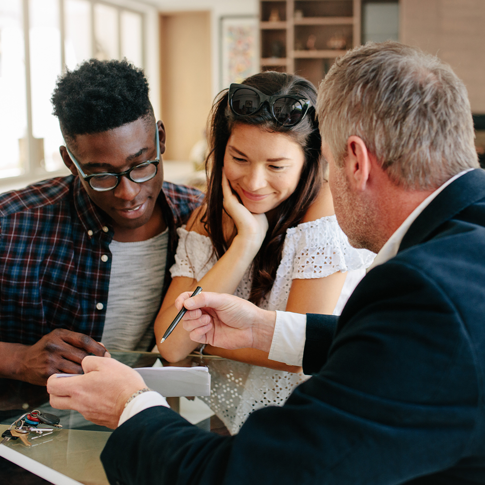 young couple talking with a real estate broker